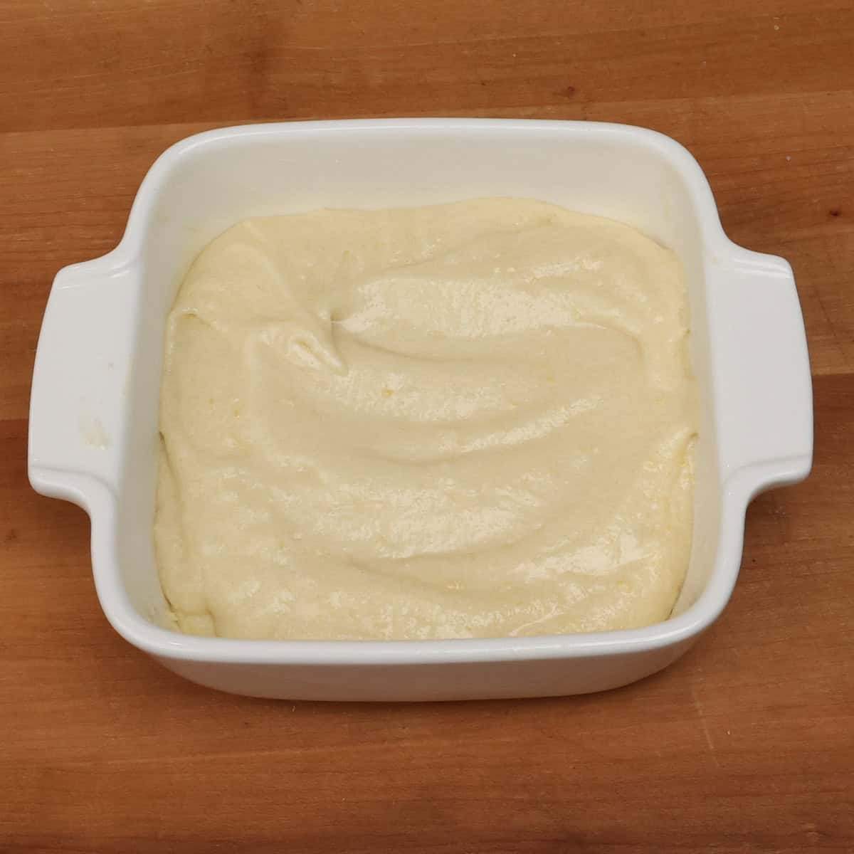 lemon cake batter in a square baking dish.