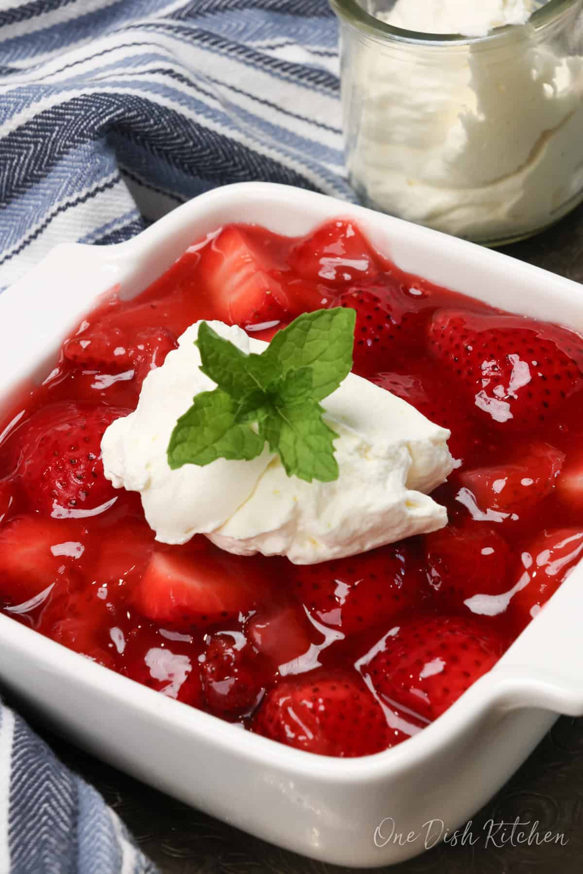 a small strawberry pie topped with whipped cream.