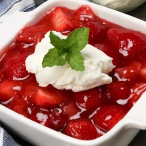 a small strawberry pie topped with whipped cream.