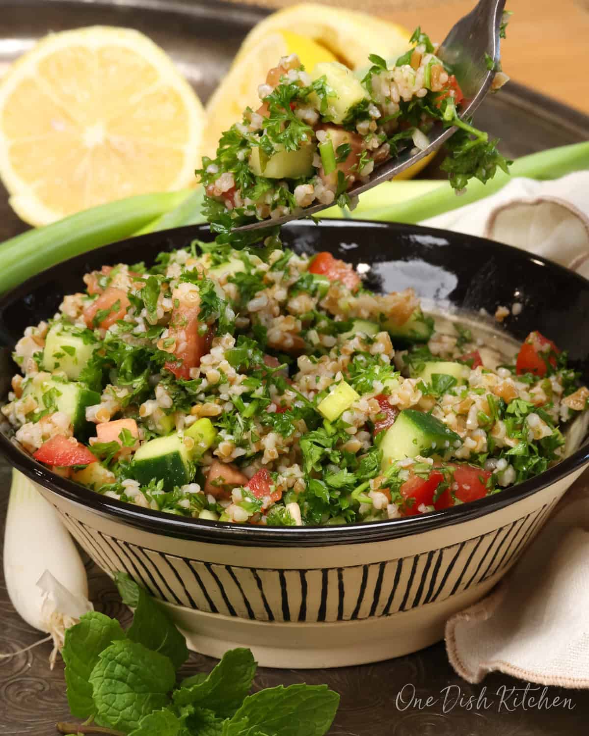 a bowl of tabbouleh with a fork on the side.