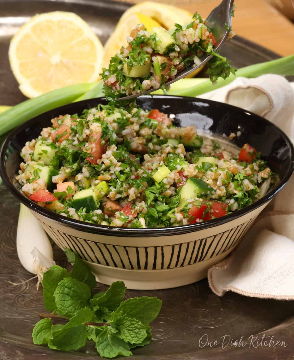 a bowl of tabbouleh with a fork above the dish.