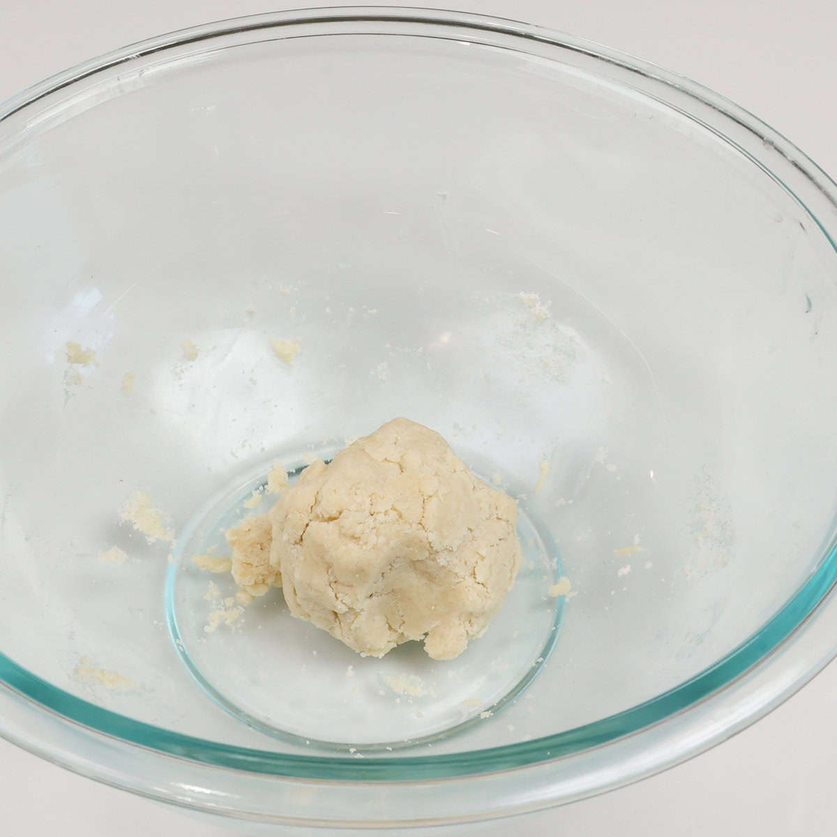 homemade pie crust rolled into a ball in a mixing bowl.