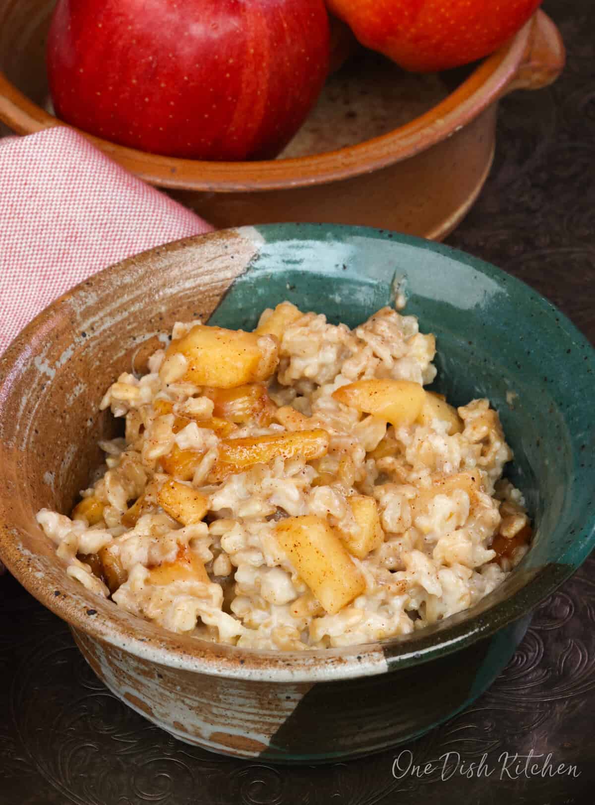 a bowl of oatmeal topped with spiced apples.