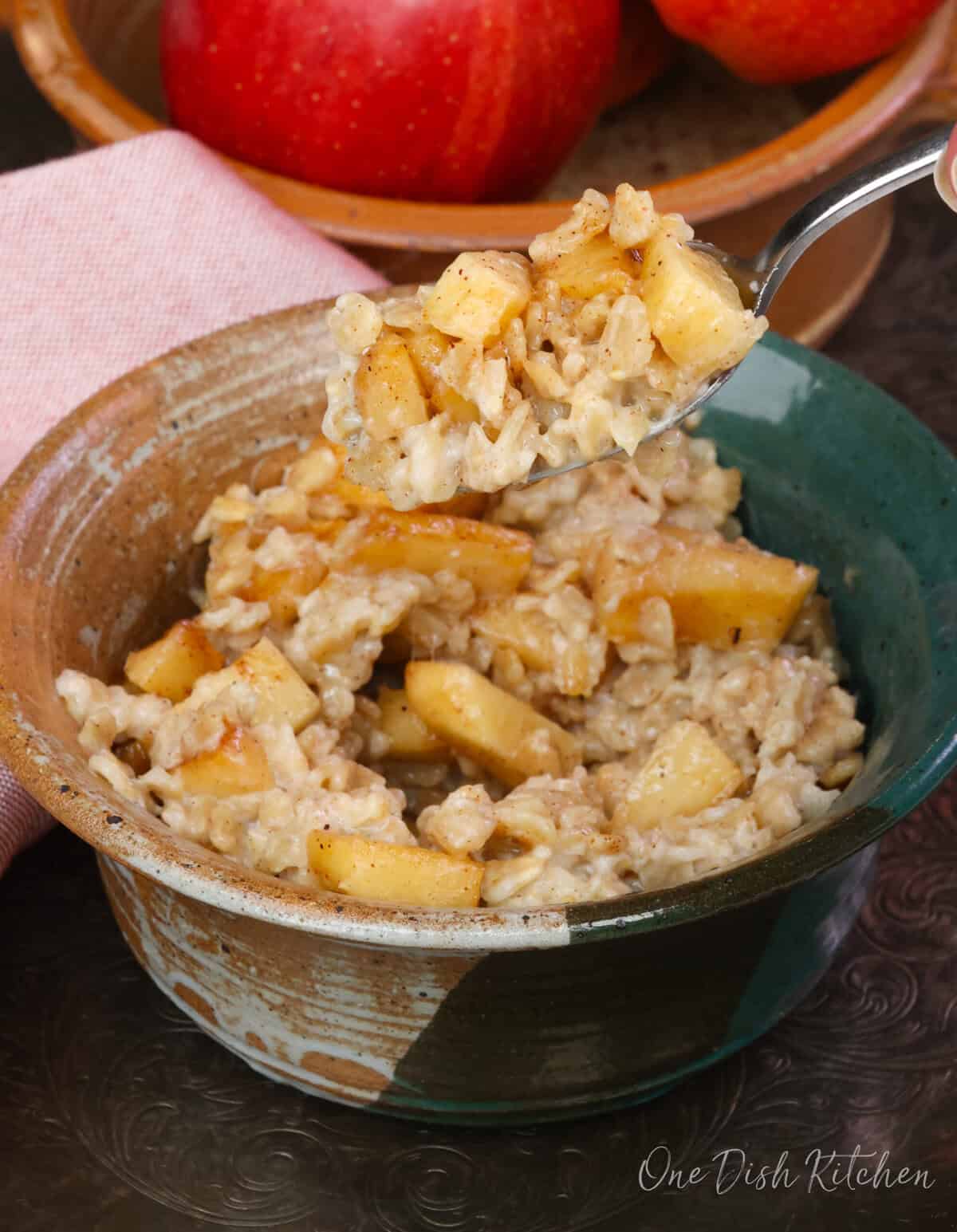 a spoonful of apple pie oatmeal above the bowl.