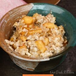 a bowl of oatmeal topped with spiced apples.