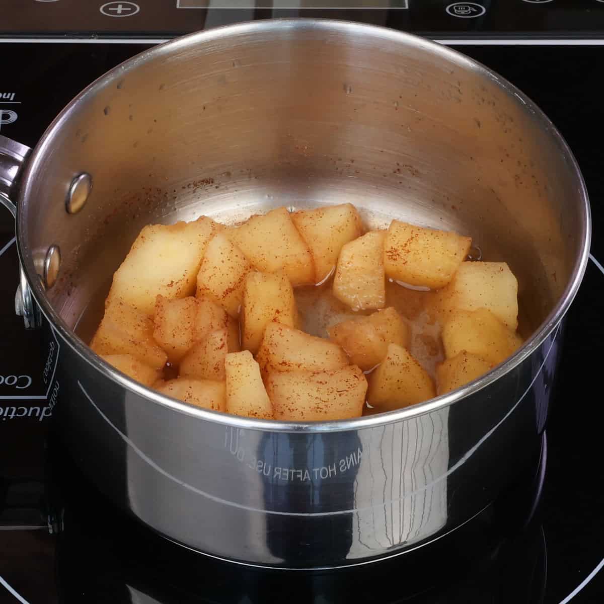 cooked apples in cinnamon in a pot.