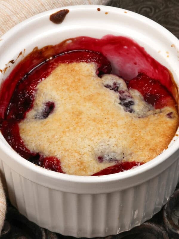 a single serving blackberry cobbler in a white ramekin.