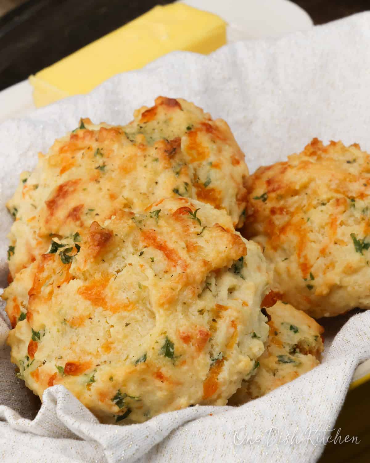 four cheddar biscuits in a bread basket.