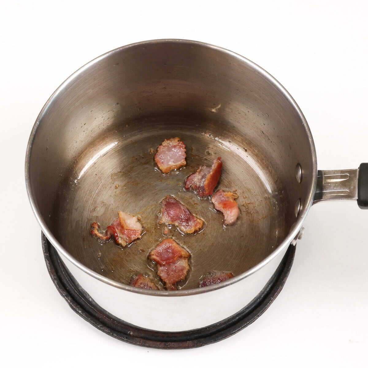 bacon pieces cooking in a pot.