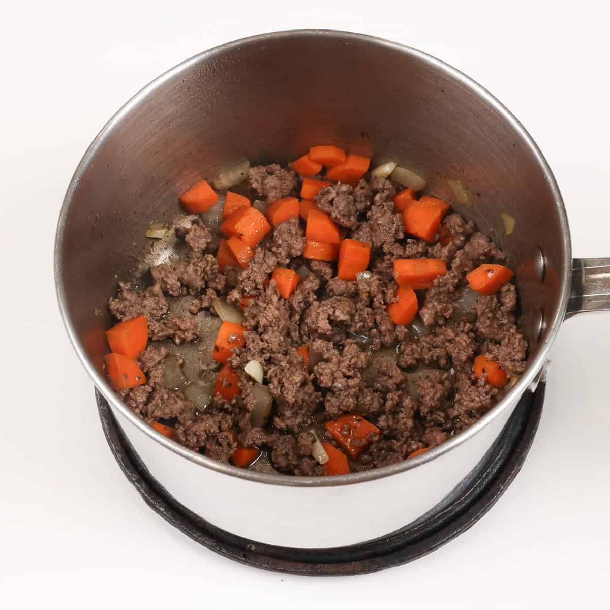 ground beef and carrots cooking in a pot.