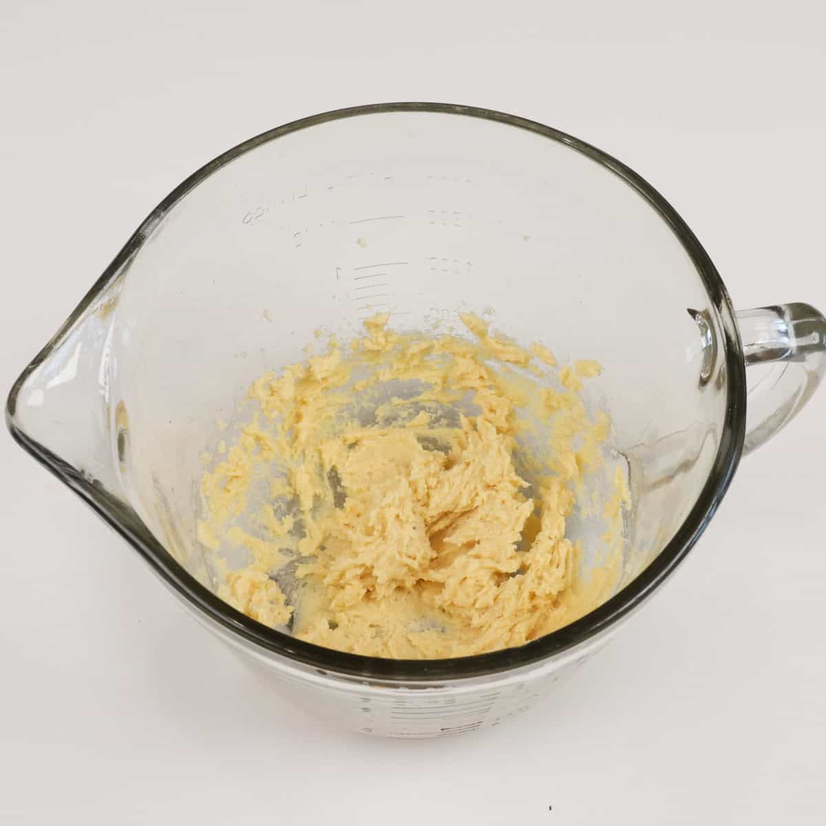 an egg yolk, sugars, and butter in a mixing bowl.