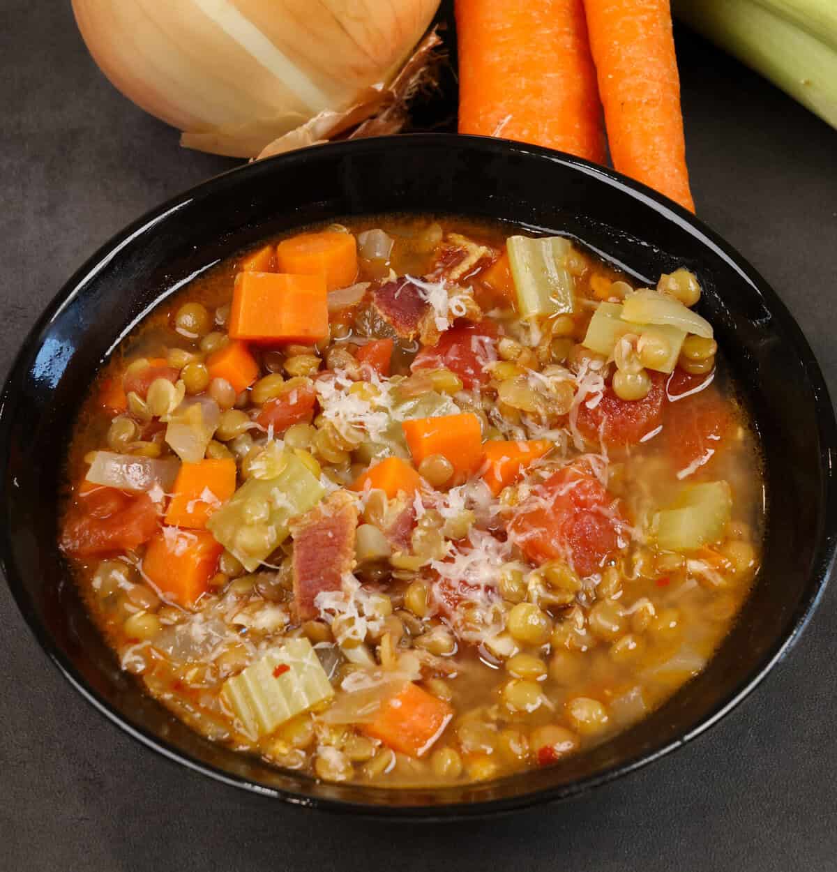 a bowl of lentil soup topped with parmesan cheese.