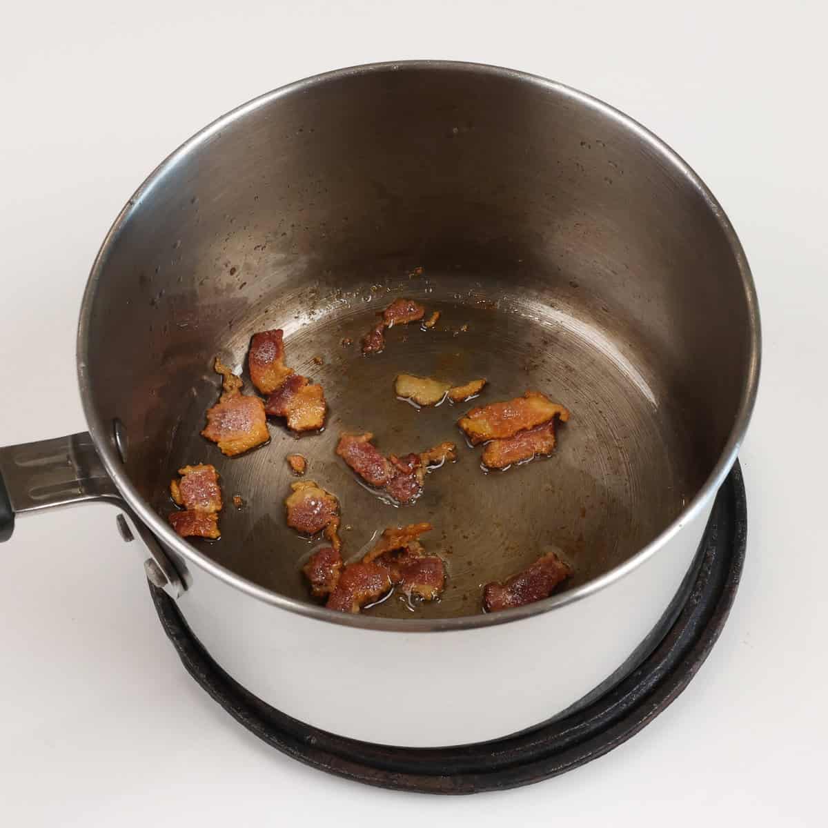 bacon cooking in a small saucepan.