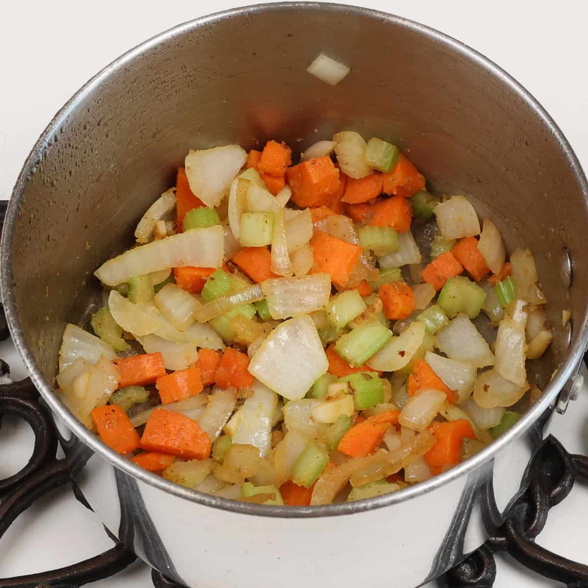 flour mixed with onions, celery and carrots in a pot.