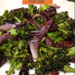 charred broccolini on a plate with red onions and kalamata olives.