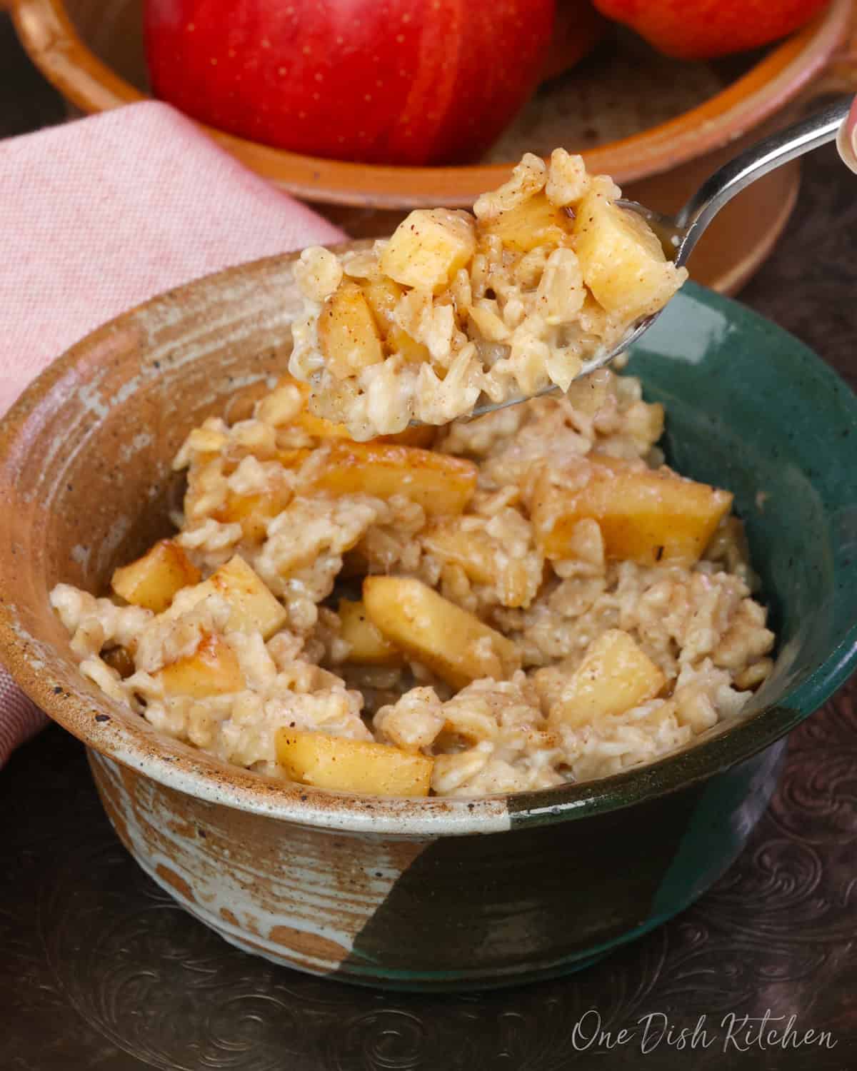 a spoonful of apple pie oatmeal above the bowl.