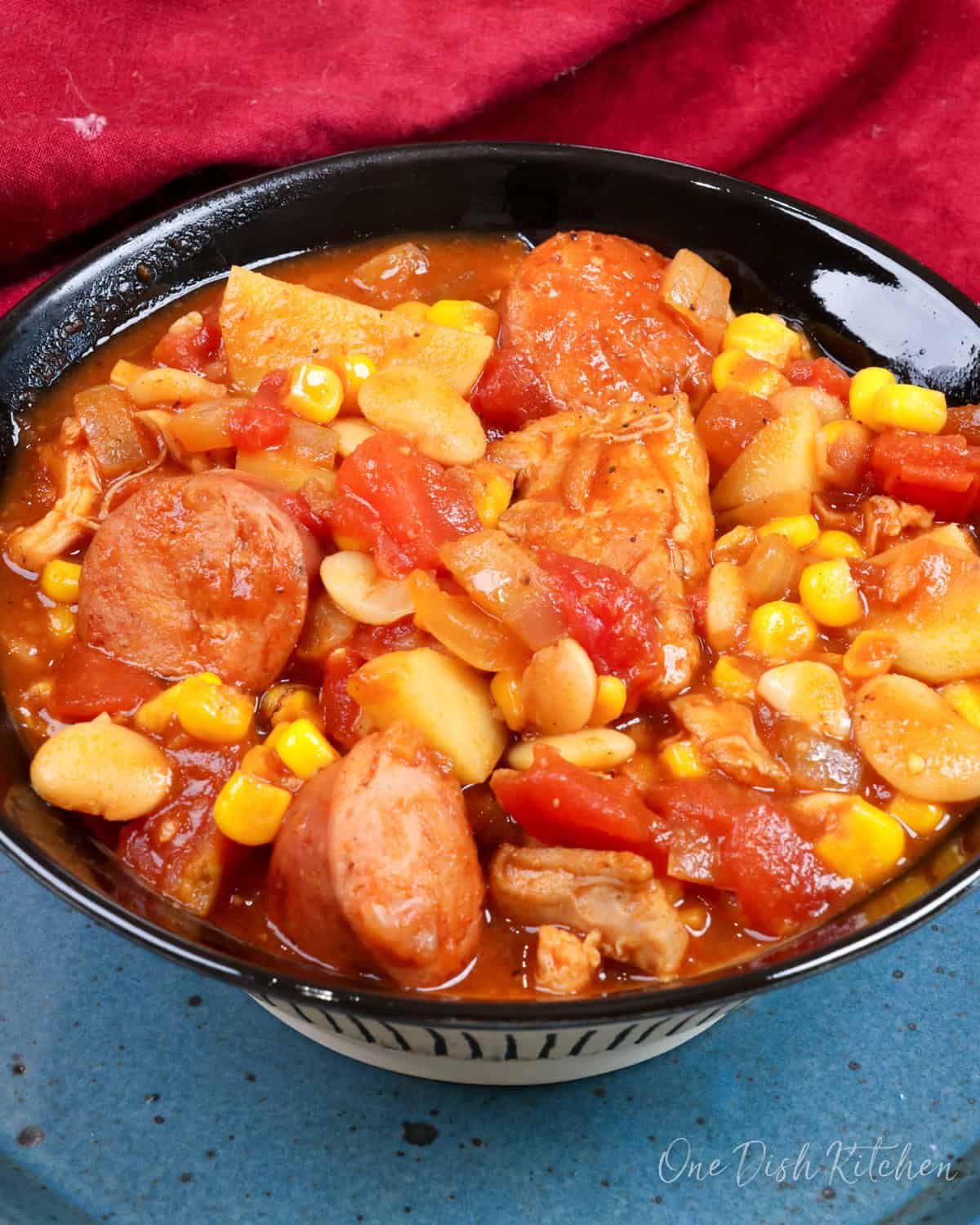 a bowl of southern brunswick stew next to a red napkin.