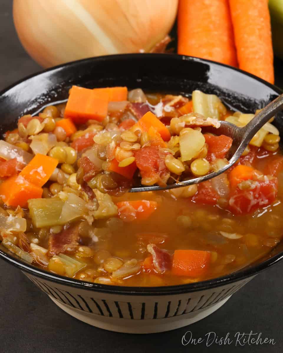 a bowl of lentil soup with a spoon on the side.
