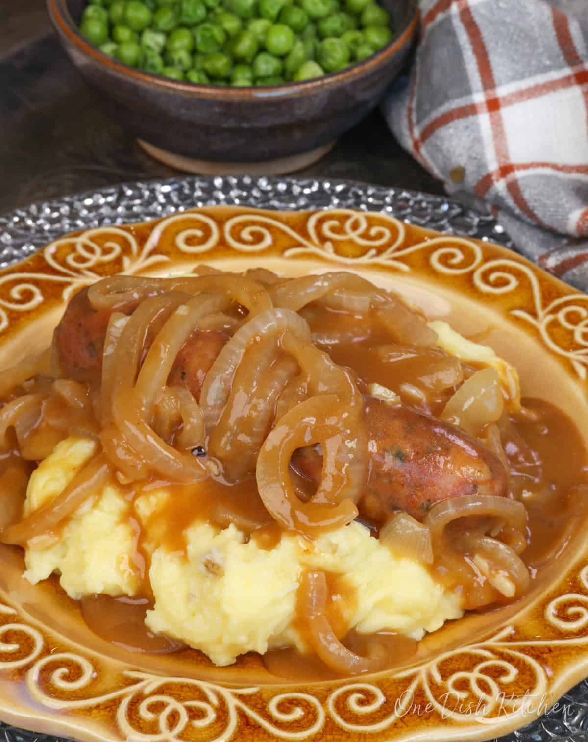 bangers and mash on a gold plate.