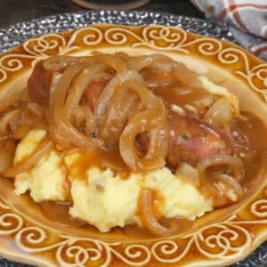 bangers and mash on a gold plate.