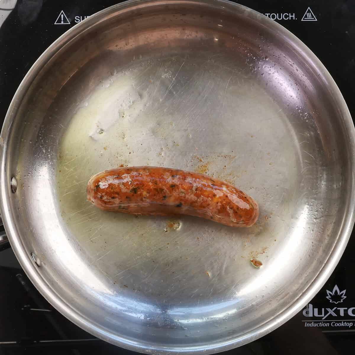 Pork sausage browning in a skillet.