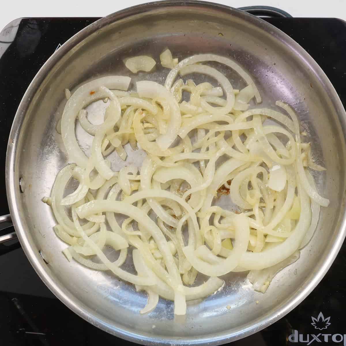 onions and garlic cooking in a skillet.