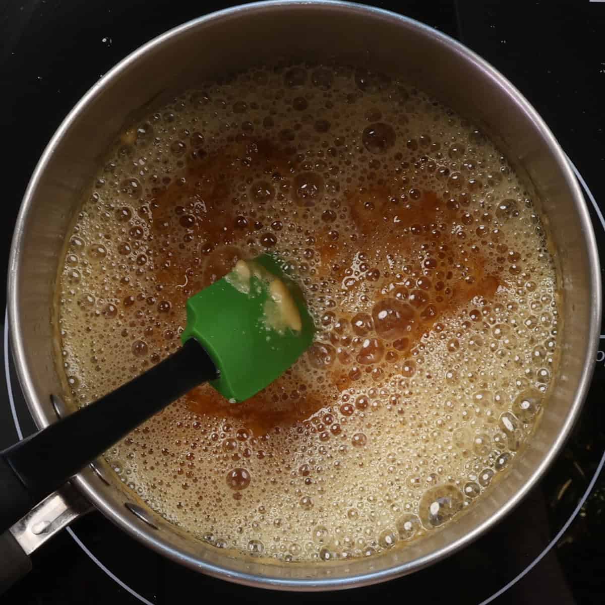 butter added to melted sugar in a saucepan.