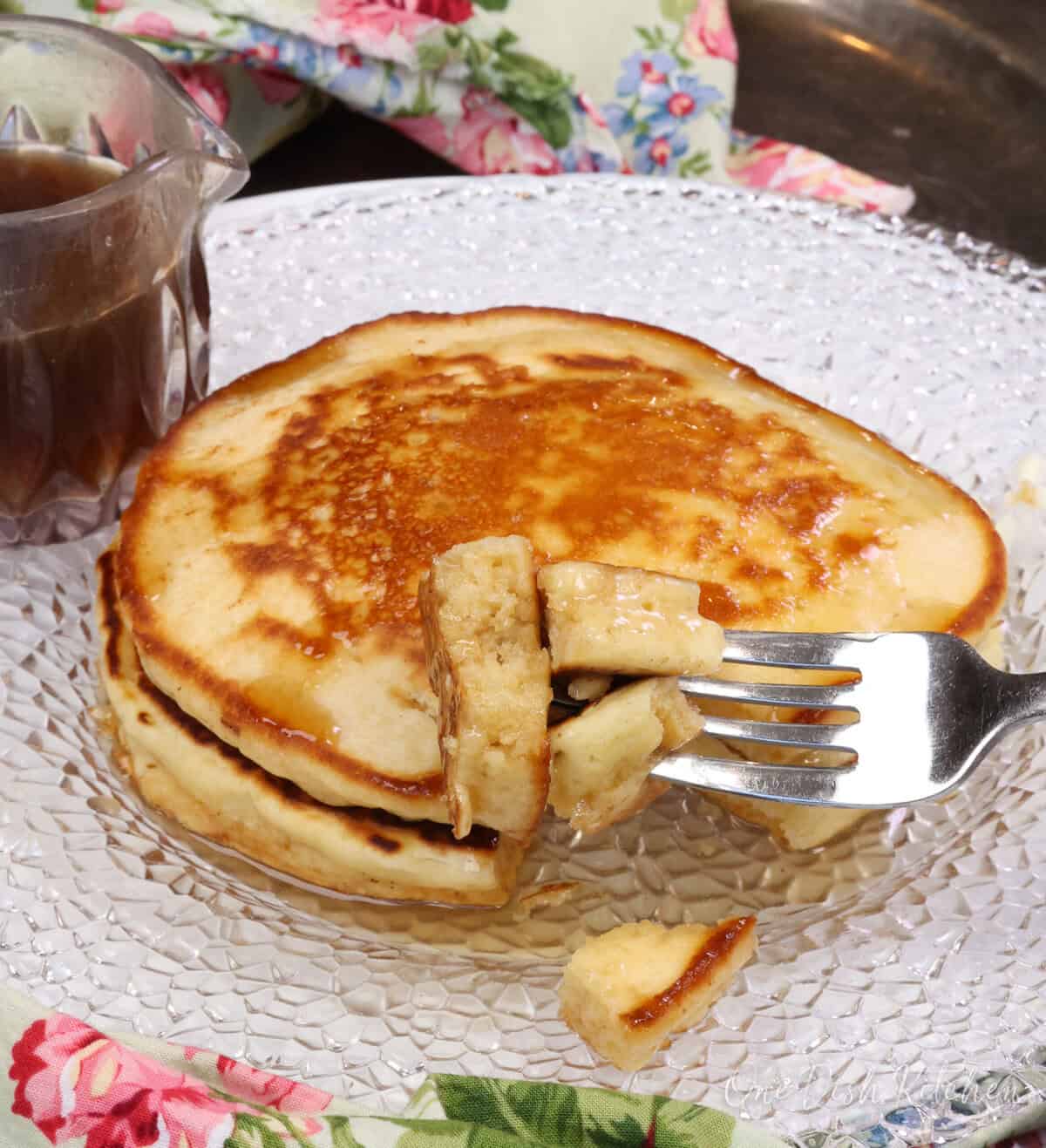 pancakes with syrup on a white plate.