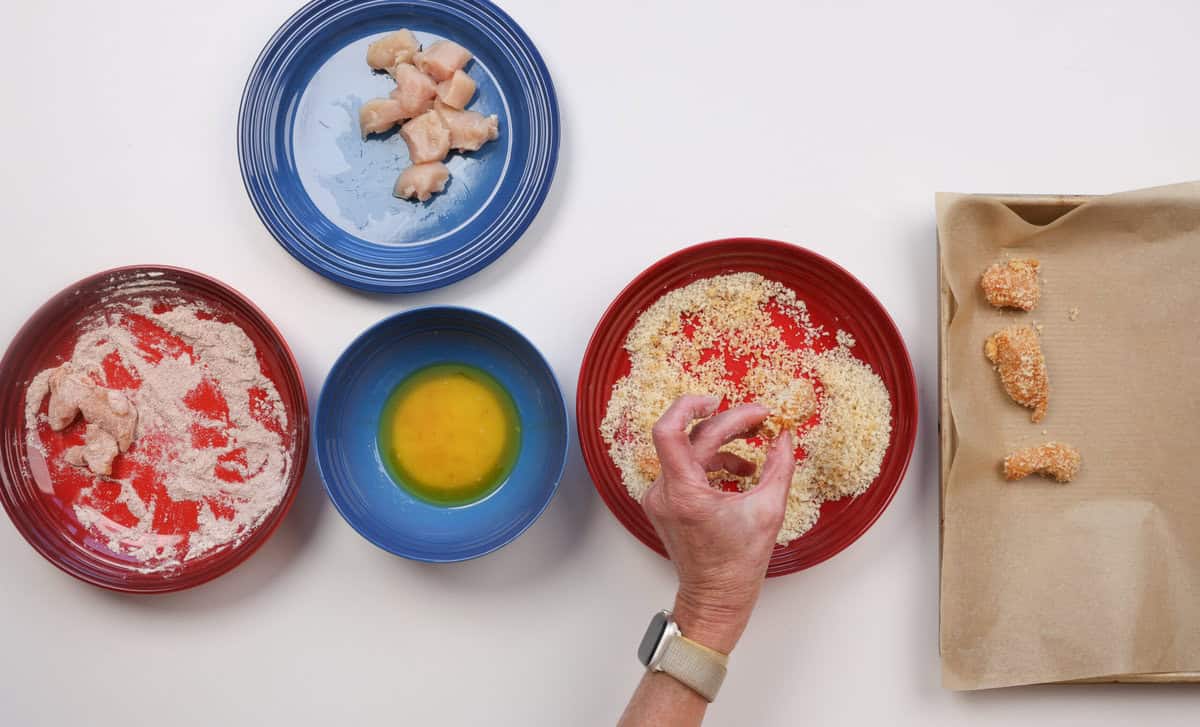 making popcorn chicken on a kitchen table.