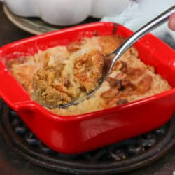 a small pumpkin dump cake in a square red baking dish with a spoon on the side.