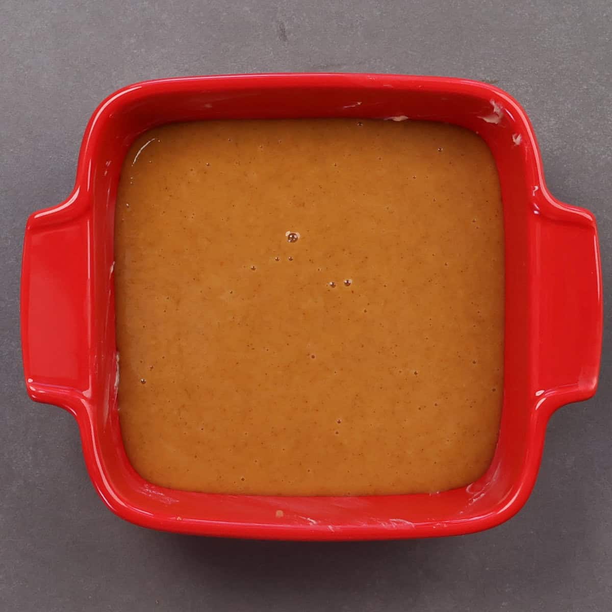 pumpkin filling in a small red baking dish.