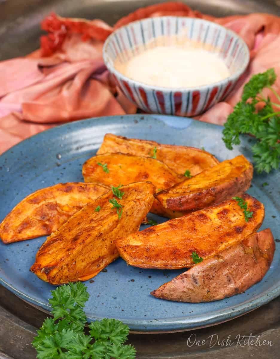 roasted sweet potato wedges on a blue plate.