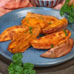 roasted sweet potato wedges on a blue plate.