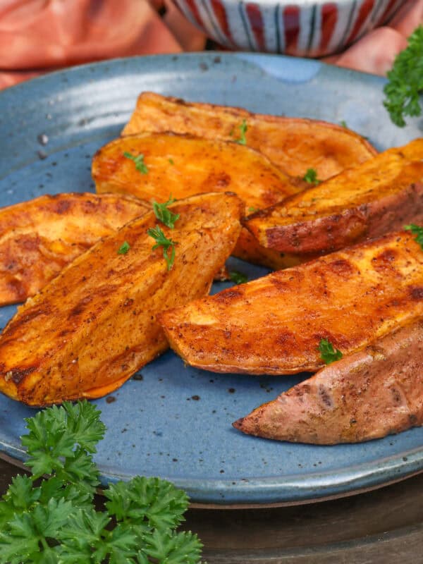 roasted sweet potato wedges on a blue plate.