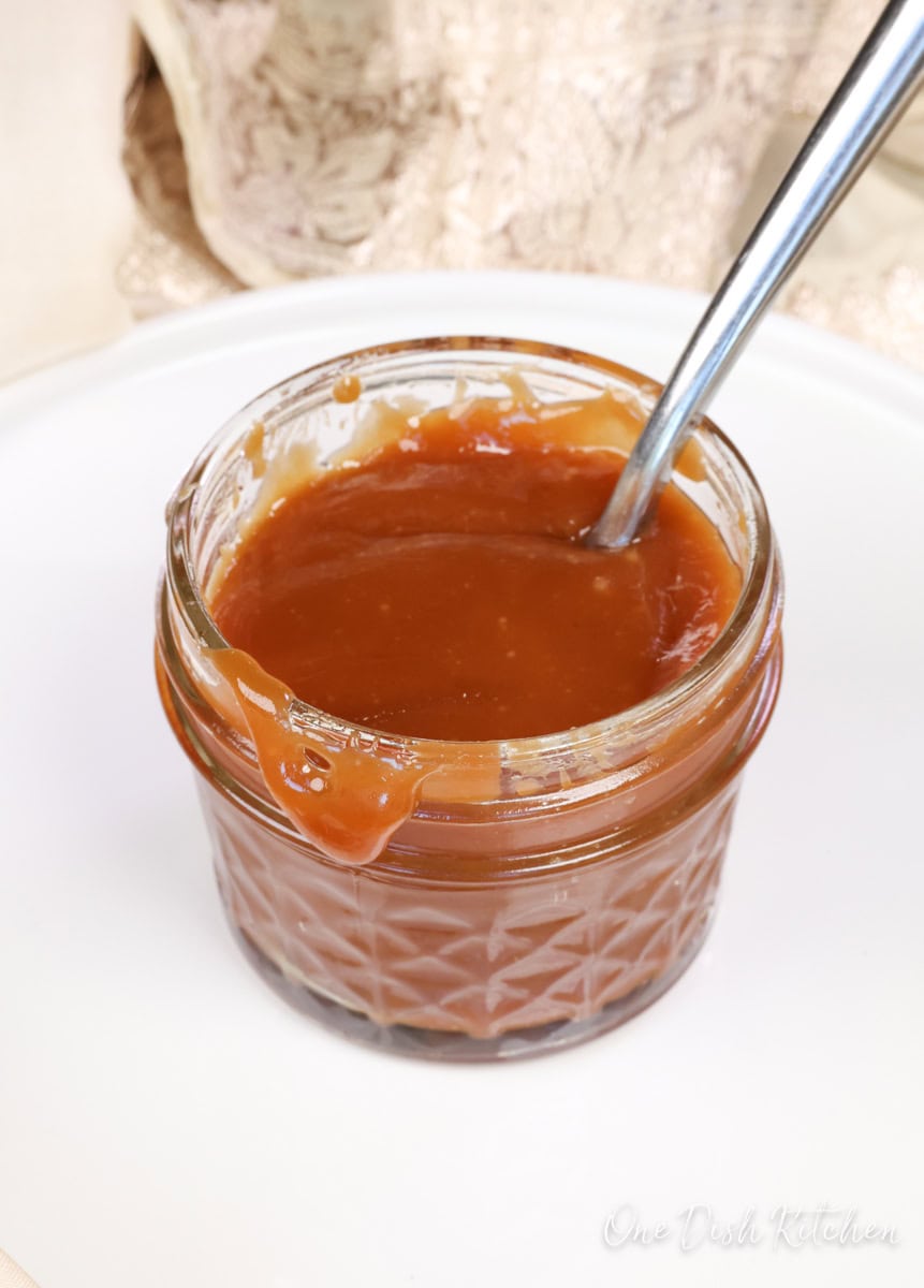 a jar of caramel with the caramel running down the sides.