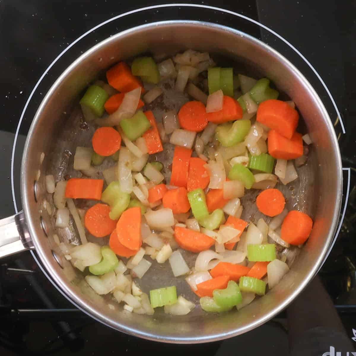 carrots, celery, onions and garlic sauteeing in a pot.