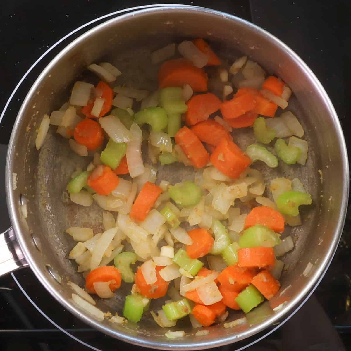 the base of cheeseburger soup, vegetables and flour, in a pot.