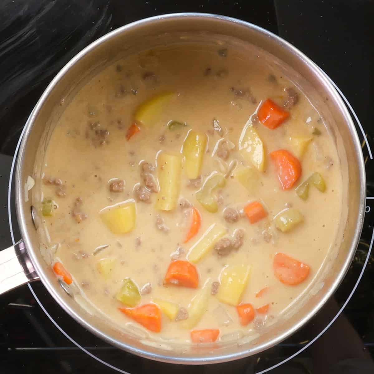 cheeseburger soup simmering in a pot.