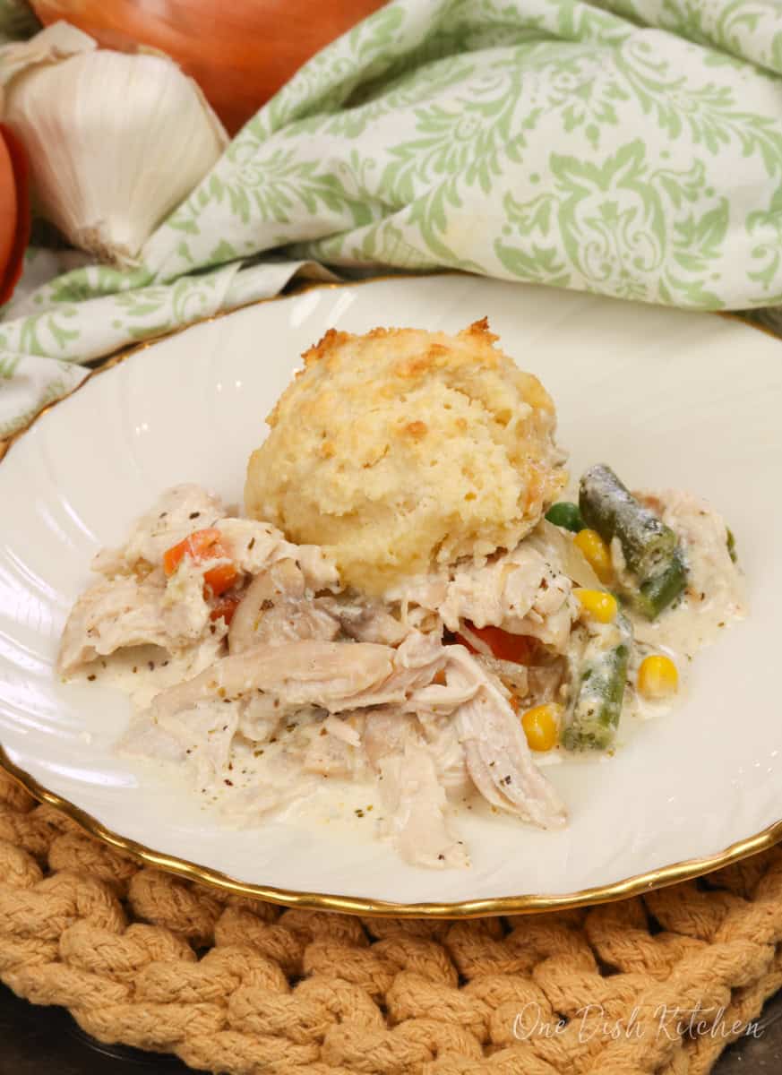 chicken casserole topped with a biscuit on a plate.