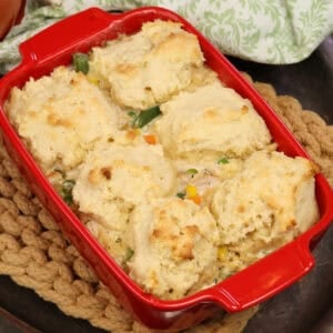 a small chicken and biscuits casserole on a silver tray.