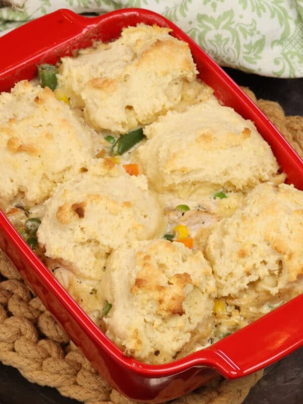 a small chicken and biscuits casserole on a silver tray.