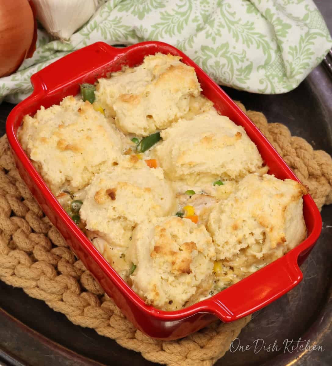 a small chicken and biscuits casserole on a silver tray.