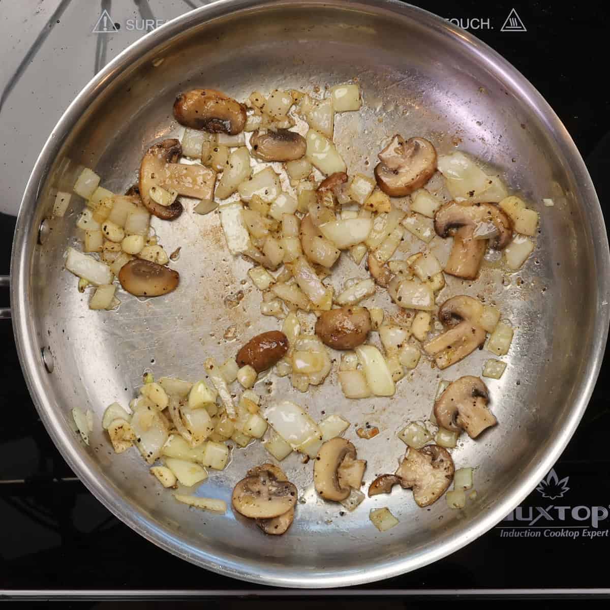 mushrooms, onions, and garlic cooking in a skillet.