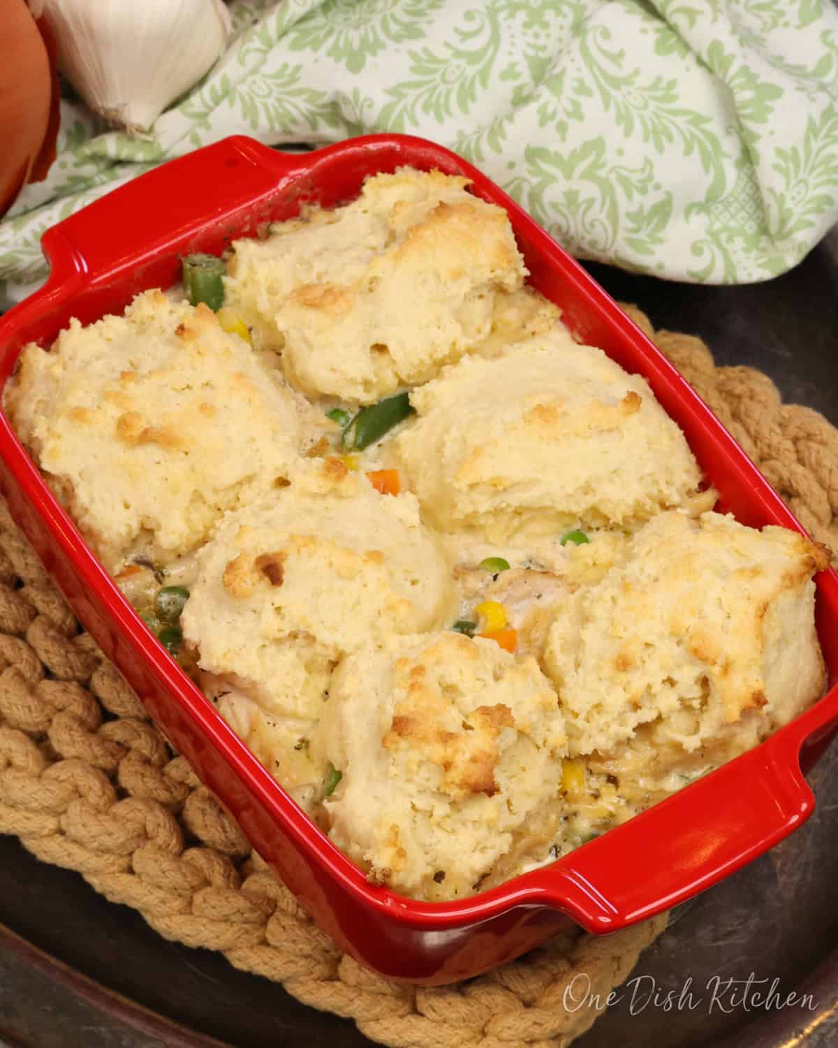 a small chicken and biscuits casserole on a silver tray.