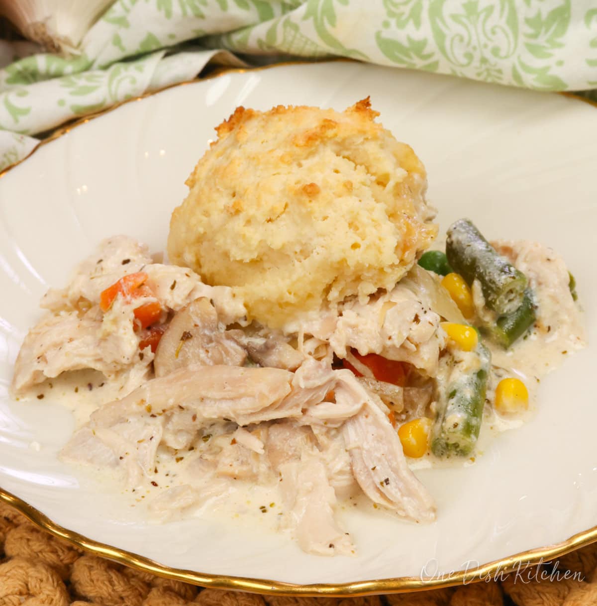 a white plate filled with homemade chicken and biscuits.