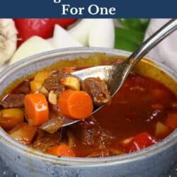 a bowl of hungarian goulash with a spoon on the side.