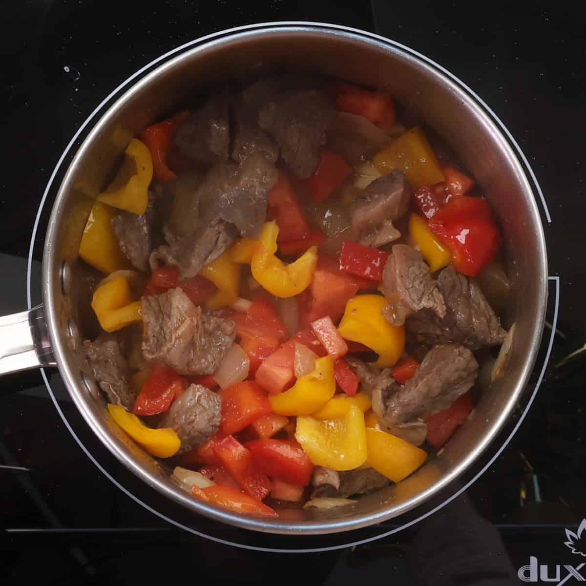 beef and vegetables cooking in a pot.