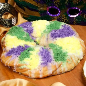 a mini king cake with a cream cheese filling and topped with colored sugar.