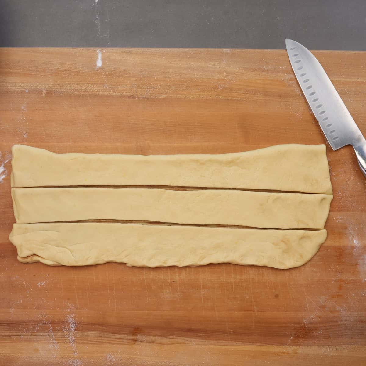 king cake dough cut into 3 strips for braiding.