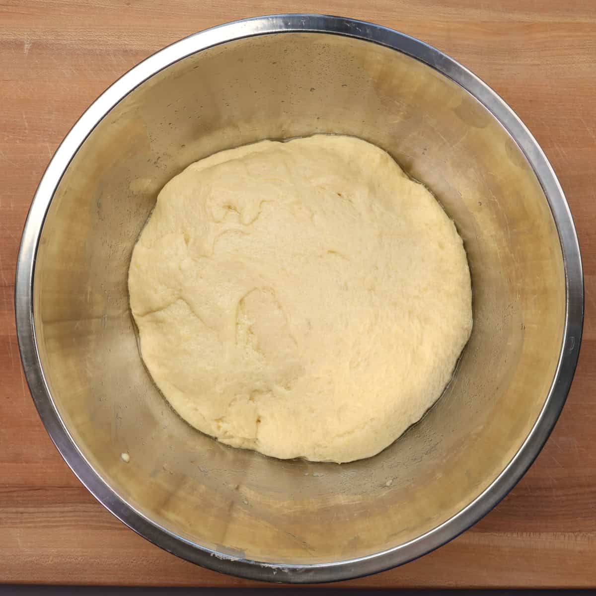 king cake dough that has risen in a mixing bowl.